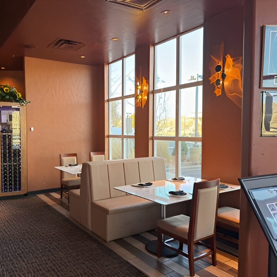 Jazmine Asian restaurant interior with booth seating, tables, chairs, large windows, and a wine rack.
